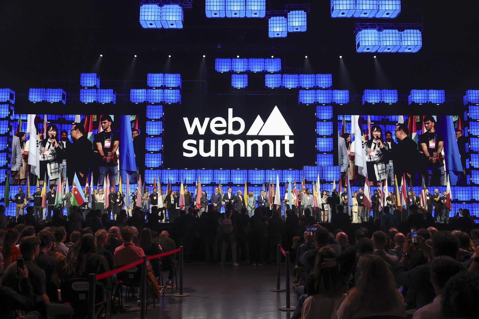 Los participantes sostienen banderas nacionales durante la sesión inaugural este lunes de la Web Summit Lisboa 2025, la conferencia tecnológica más grande del mundo. EFE/EPA/MANUEL DE ALMEIDA