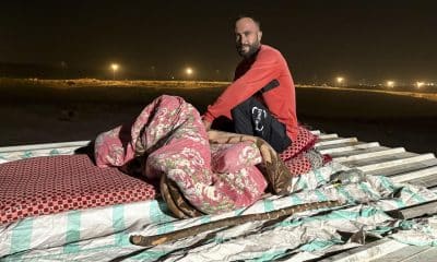 El palestino Saber Abu Aram se acomoda en un colchón sobre el tejado, donde va a dormir. EFE/Nuria Garrido