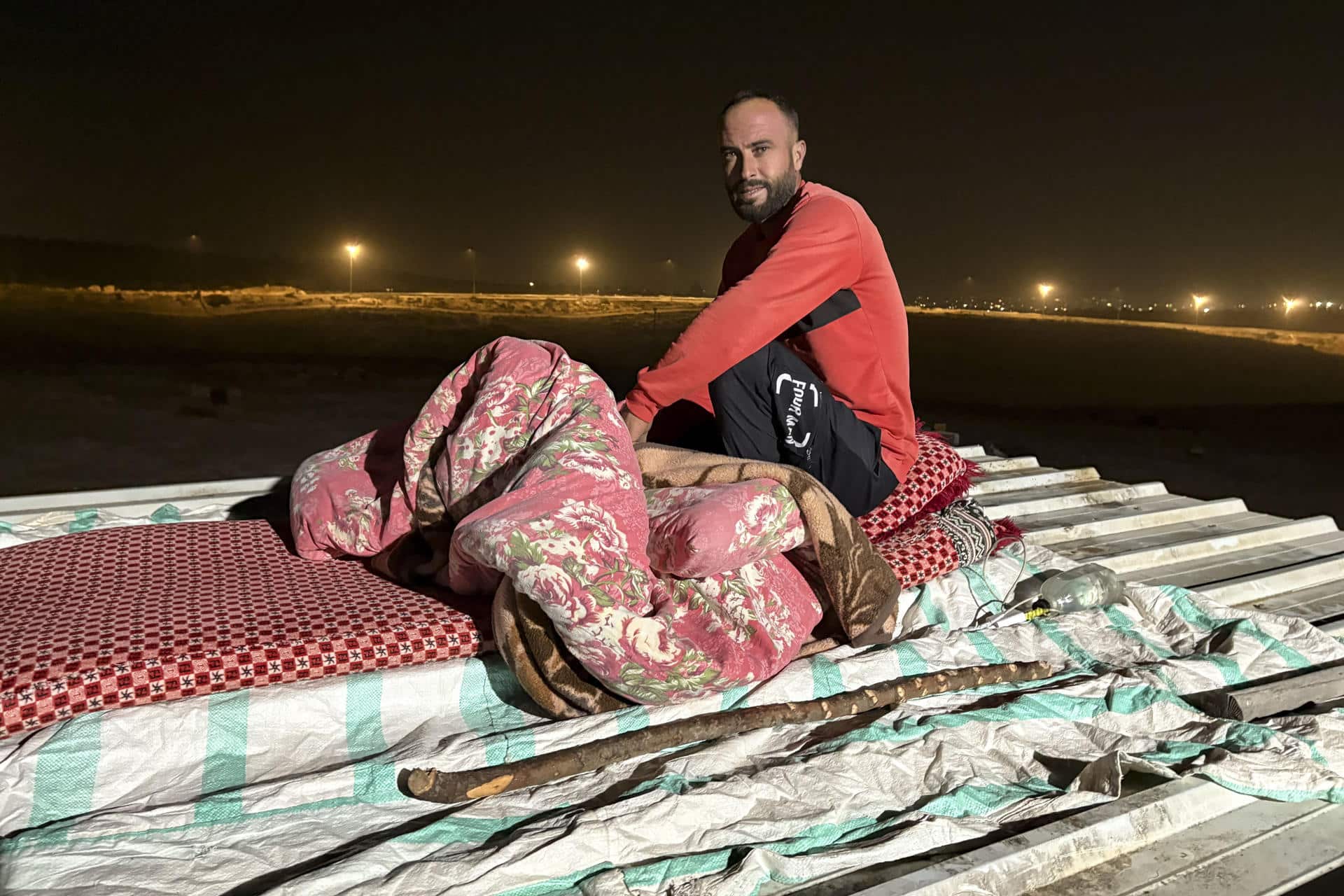 El palestino Saber Abu Aram se acomoda en un colchón sobre el tejado, donde va a dormir. EFE/Nuria Garrido