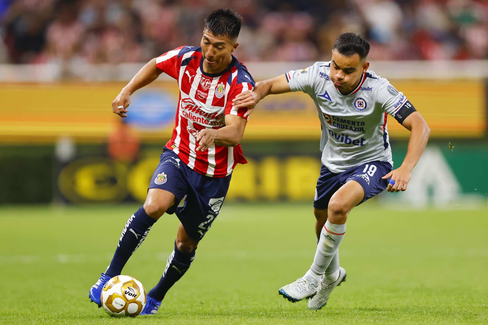 Daniel Aguirre (i), del Guadalajara, disputa el balón con Carlos Rodríguez, de Cruz Azul, este jueves en un partido de cuartos final de la Liga MX en el Estadio Akron, en Guadalajara (México). EFE/ Francisco Guasco