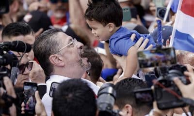 El presidente de Costa Rica, Rodrigo Chaves, alza a un niño luego de una audiencia este viernes, en el exterior del Congreso en San José (Costa Rica). Chaves arengó a sus seguidores y cantó con ellos 'Llegó papá', tras la audiencia en una comisión legislativa que estudia una solicitud de desafuero presentada por el Tribunal Supremo de Elecciones (TSE) que le acusa de intervenir en temas electorales y políticos. EFE/ Jeffrey Arguedas