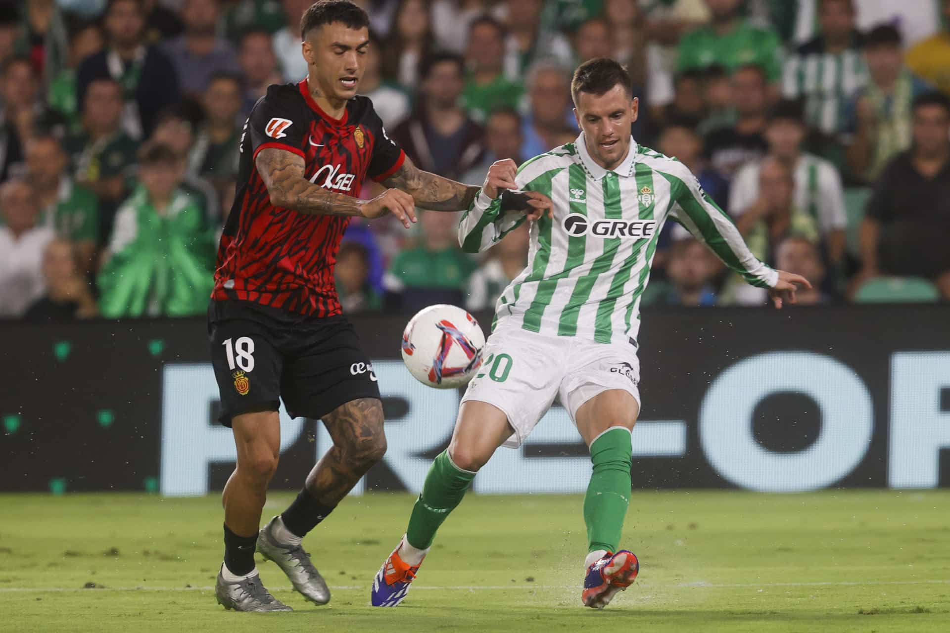 El centrocampista argentino del Betis, Giovani Lo Celso (d), disputa el balón ante el centrocampista del Mallorca, Antonio Sánchez, en el estadio Benito Villamarín, en Sevilla en foto de archivo de José Manuel Vidal. EFE
