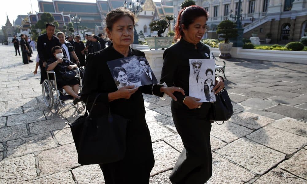 Dos mujeres tailandesas con retratos de la reina madre Sirikit y su esposo, el fallecido rey Bhumibol Adulyadej, hacen fila para rendir homenaje a la difunta en el Salón del Trono Dusit Maha Prasat dentro del Gran Palacio en Bangkok, Tailandia, el 9 de noviembre de 2025. EFE/EPA/RUNGROJ YONGRIT
