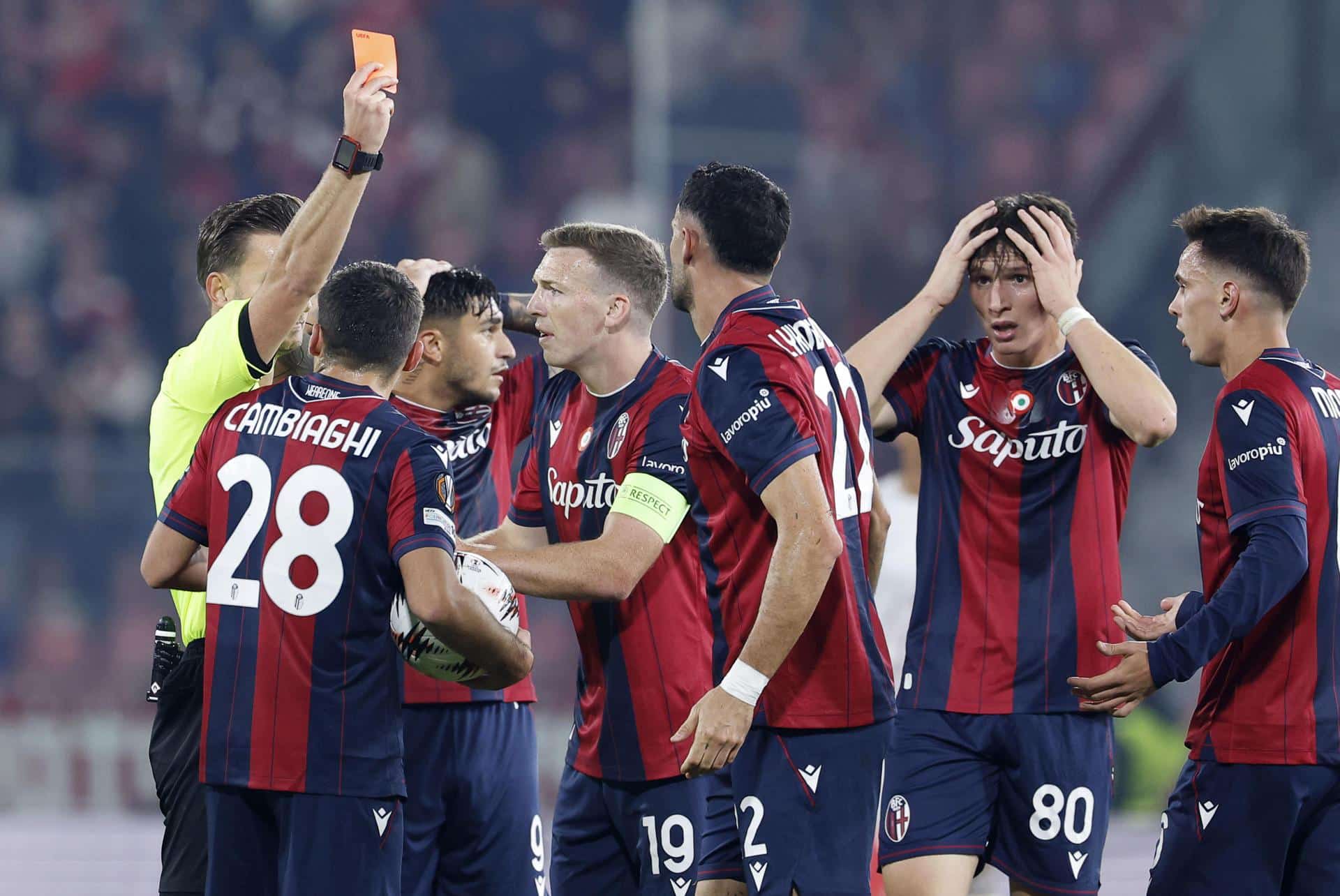 Futbolistas del Bolonia reaccionan a la tarjeta roja mostrada por el árbitro Daniel Slagher (i) a Charalampos Lykogiannis durante el partido de Liga Europa disputado este jueves entre su equipo y el Brann. EFE/ ELISABETTA BARACCHI