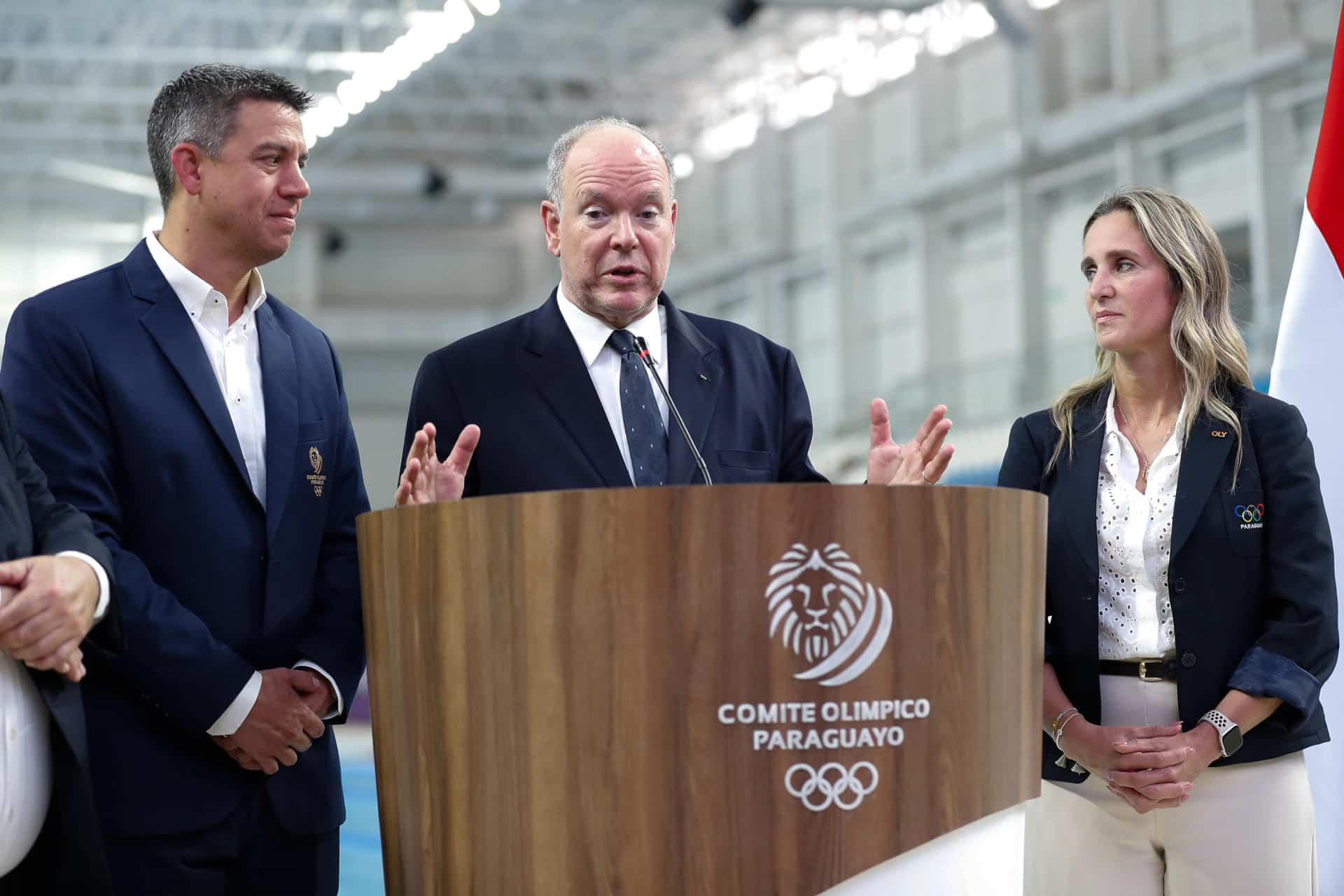 El príncipe Alberto II de Mónaco (c) habla junto al vicepresidente del Comité Olímpico Paraguayo, Julio Ferrari (i), y la directora general adjunta del Comité Organizador Local de grandes eventos deportivos de Paraguay, Larissa Schaerer, durante un recorrido por el Centro Acuático Olímpico de Paraguay este miércoles, en Luque (Paraguay). EFE/ Juan Pablo Pino