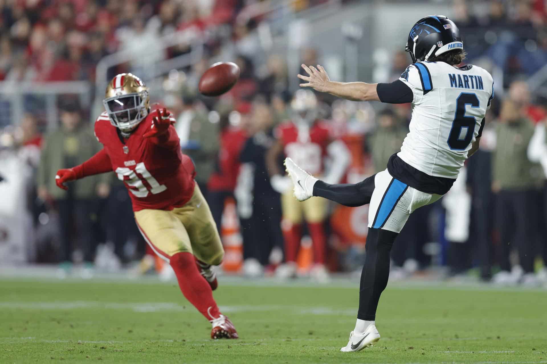 El pateador de los Carolina Panthers Sam Martin (d) patea el balón mientras Isaac Guerendo (i), de los San Francisco 49ers, defiende durante la primera mitad del partido de la NFL entre los Carolina Panthers y los San Francisco 49ers en Santa Clara, California (EE.UU.). EFE/JOHN G. MABANGLO