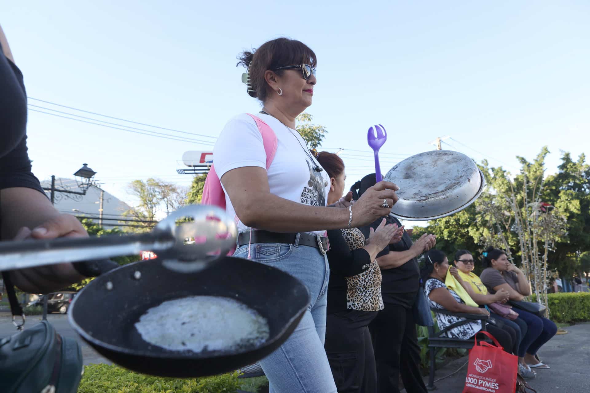 Personas participan de una protesta denominada 'Cacerolazo por otra Navidad Negra' este sábado, en San Salvador (El Salvador). Una veintena de activistas salvadoreños protestó contra los despidos arbitrarios de personal del sistema de salud gubernamental denunciados esta semana y señalaron que las denuncias de ceses de trabajadores estatales en 2025 suman más de 22.000 EFE/ Javier Aparicio