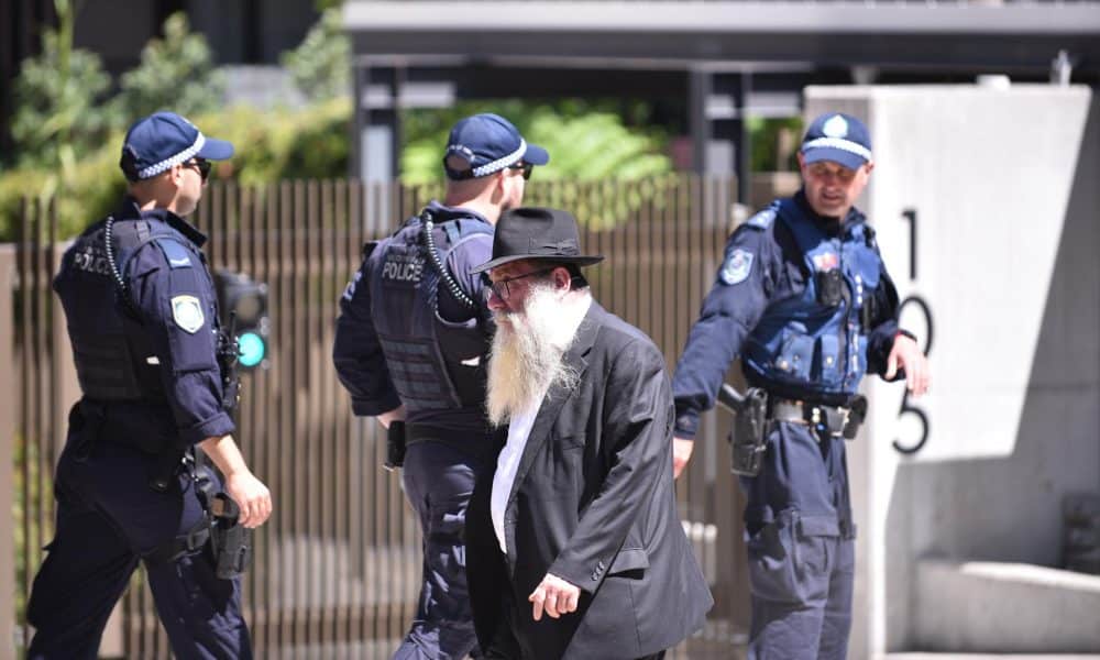 Sídney (Australia), 17/12/2025.- Un doliente pasa junto a la policía durante el servicio conmemorativo de Reuven Morrison en la sinagoga Jabad de Bondi, tras un tiroteo en Bondi Beach, Sídney, Australia, el 17 de diciembre de 2025. Reuven Morrison se encuentra entre las 15 personas que fueron asesinadas por los hombres armados mientras asistían a la celebración de Hanukkah en Bondi Beach Park el 14 de diciembre. EFE/EPA/FLAVIO BRANCALEONE AUSTRALIA AND NEW ZEALAND OUT
