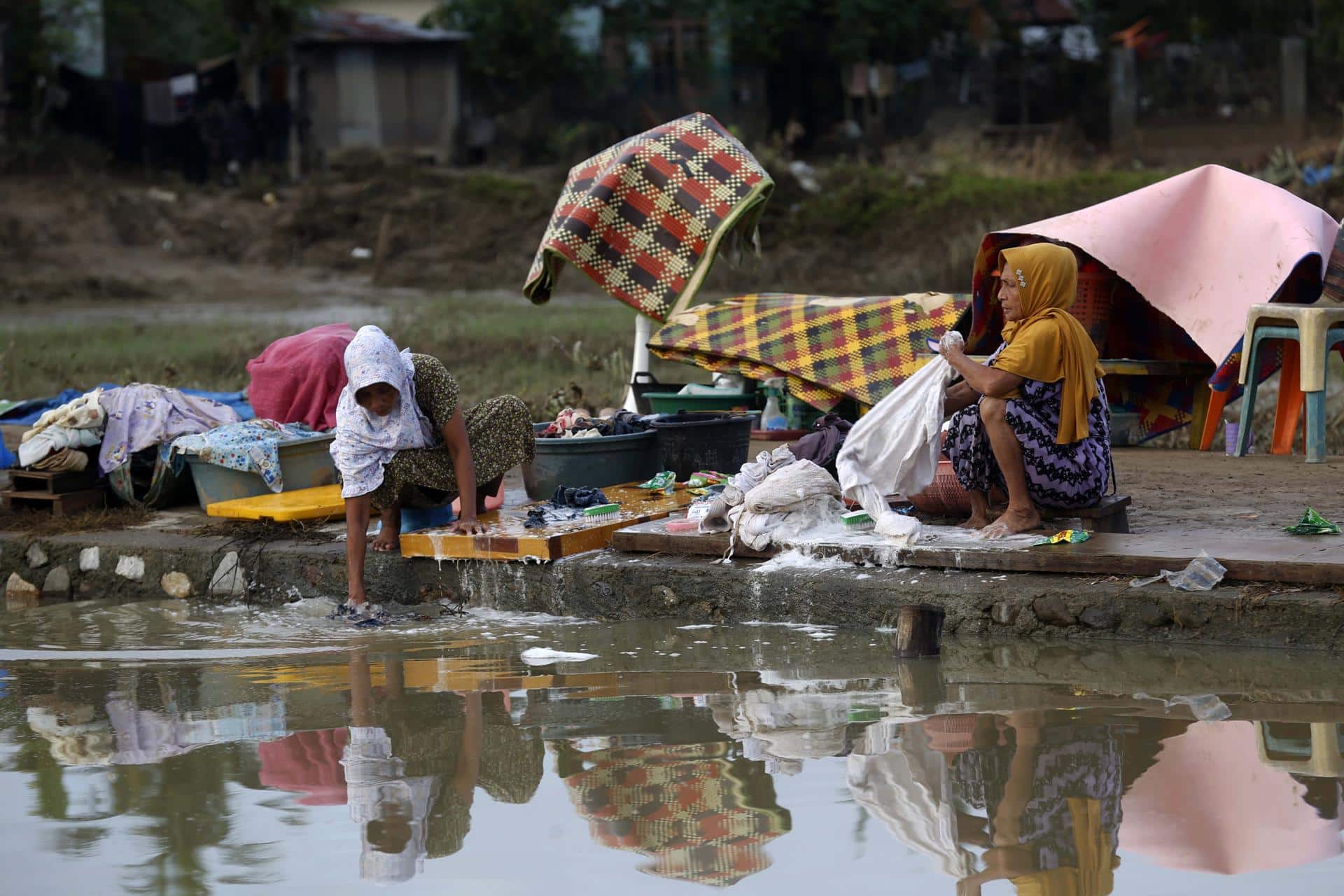 MEURUDU (Indonesia), 03/12/2025.- Residents wash their clothes at a flood-affected village in the Meureudu area of Pidie Jaya, Aceh, Indonesia, 03 December 2025. According to the National Disaster Management Agency, floods and landslides triggered by Tropical Cyclone Senyar have killed more than 750 people across Aceh, North Sumatra, and West Sumatra provinces. (Inundaciones) EFE/EPA/HOTLI SIMANJUNTAK