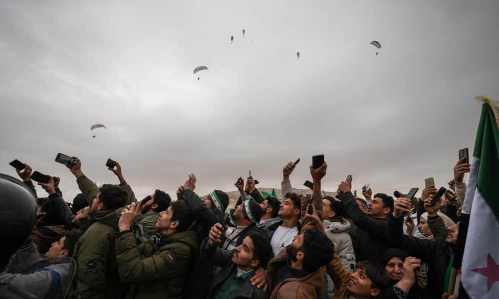 Una multitud asiste a un desfile militar este domino en Damasco por el aniversario de la caída de Bashar Al-Assad. EFE/EPA/AHMAD FALLAHA