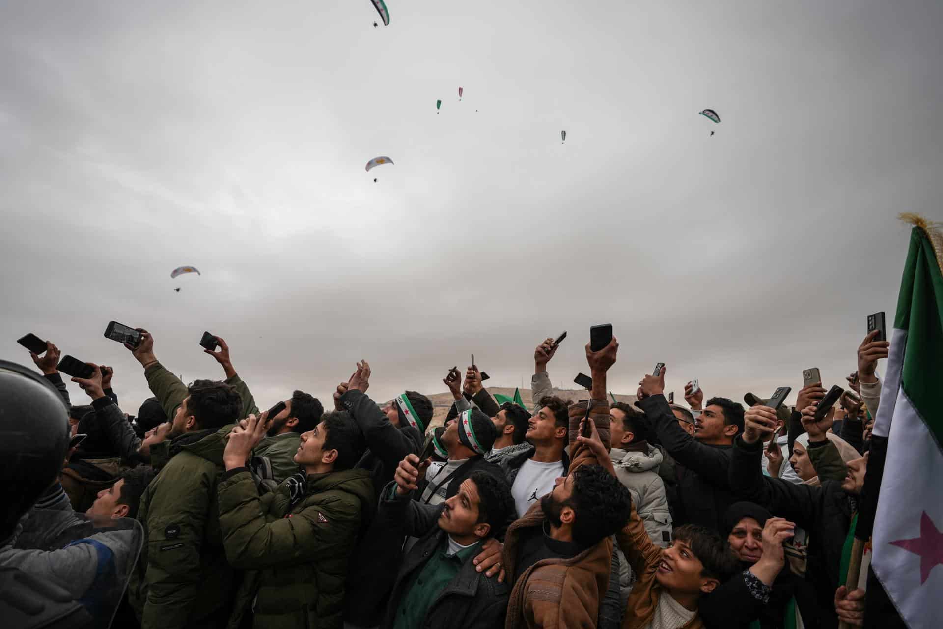 Una multitud asiste a un desfile militar este domino en Damasco por el aniversario de la caída de Bashar Al-Assad. EFE/EPA/AHMAD FALLAHA