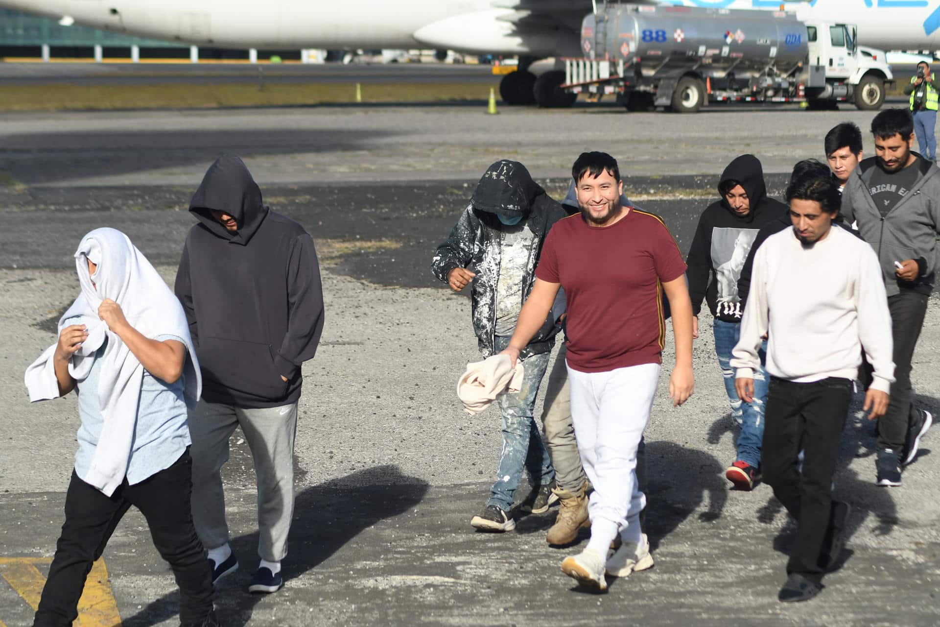 Personas caminan en la base de la Fuerza Aérea Guatemalteca (FAG) luego de la llegada del último vuelo de ciudadanos deportados procedentes de Estados Unidos este martes,  en Ciudad de Guatemala (Guatemala). EFE/ Alex Cruz
