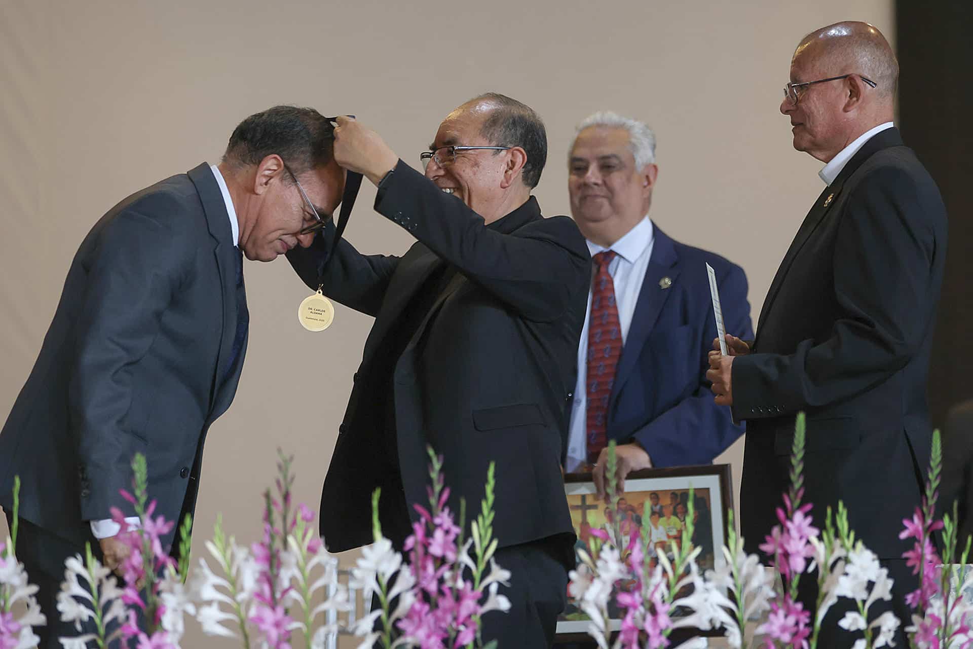 El canciller de la Arquidiócesis de Santiago de Guatemala, Antonio Zuleta (c), entrega al viceministro de Educación Extraescolar y Alternativa, Doctor Carlos Aldana Mendoza, (i) la Orden Monseñor Juan José Gerardi de los Derechos Humanos 2025 en la conmemoración del Día Internacional de los Derechos Humanos este miércoles, en Ciudad de Guatemala (Guatemala). EFE/ Mariano Macz