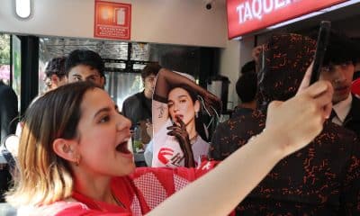 Una mujer se toma una fotografía junto a un cartel de la cantante británica Dua Lipa durante la apertura de la taquería 'La Dua' este lunes, en Ciudad de México (México). EFE/ Mario Guzmán
