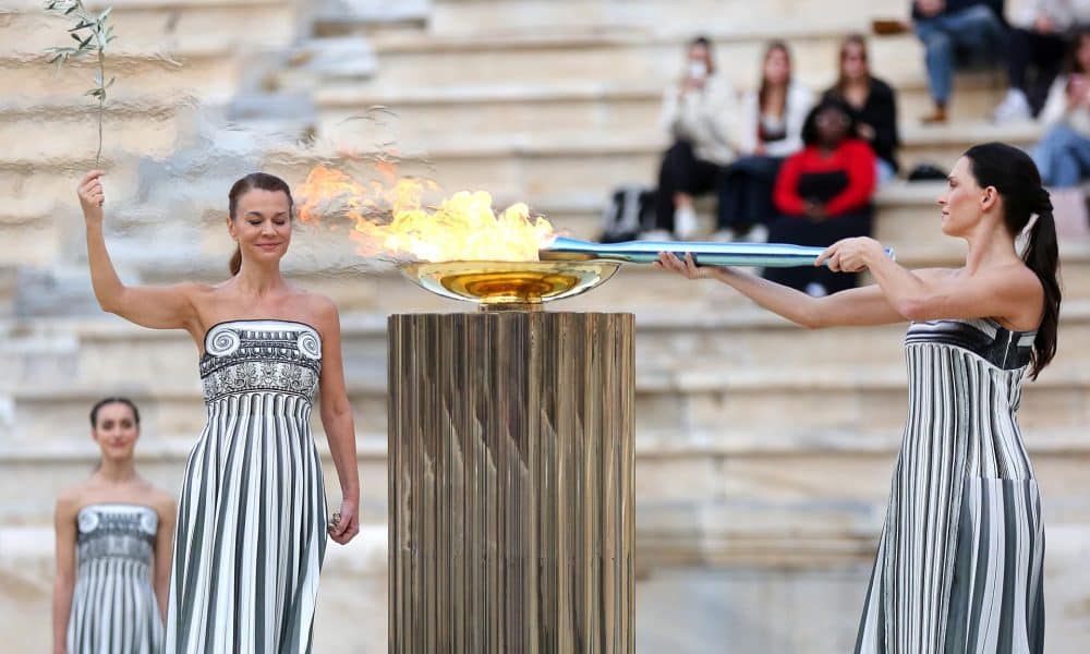 La actriz griega Mary Mina, en el papel de la Suma Sacerdotisa, enciende la Antorcha Olímpica durante la ceremonia de entrega de la Llama Olímpica para los Juegos Olímpicos de Invierno Milano Cortina 2026, en el Estadio Panatenaico de Atenas, Grecia, este jueves. EFE/ Orestis Panagiotou