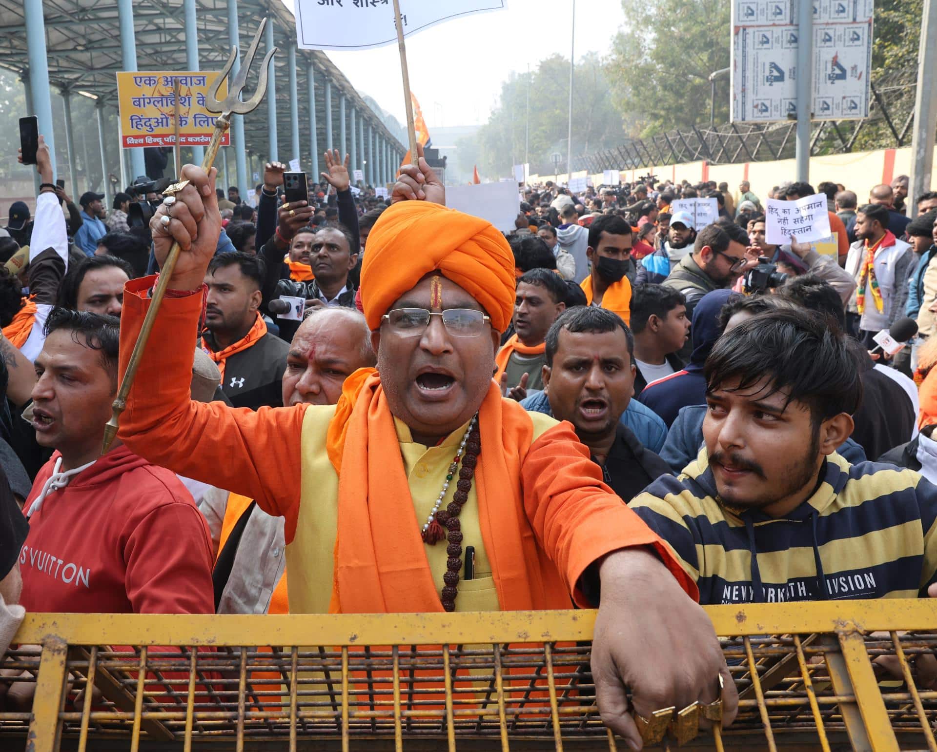 Activistas indios de las organizaciones Bajrang Dal y Vishva Hindu Parishad (VHP) gritan consignas mientras intentan escalar las barricadas policiales durante una protesta contra el linchamiento de un trabajador hindú en Bangladesh, cerca de la Alta Comisión de Bangladesh en Nueva Delhi, India, 23 de diciembre de 2025. Dipu Chandra Das, un trabajador hindú en Bangladesh, fue presuntamente linchado por una turba por la acusación de blasfemia en el distrito de Mymensingh el 18 de diciembre. (Protestas, Nueva Delhi) EFE/EPA/RAJAT GUPTA