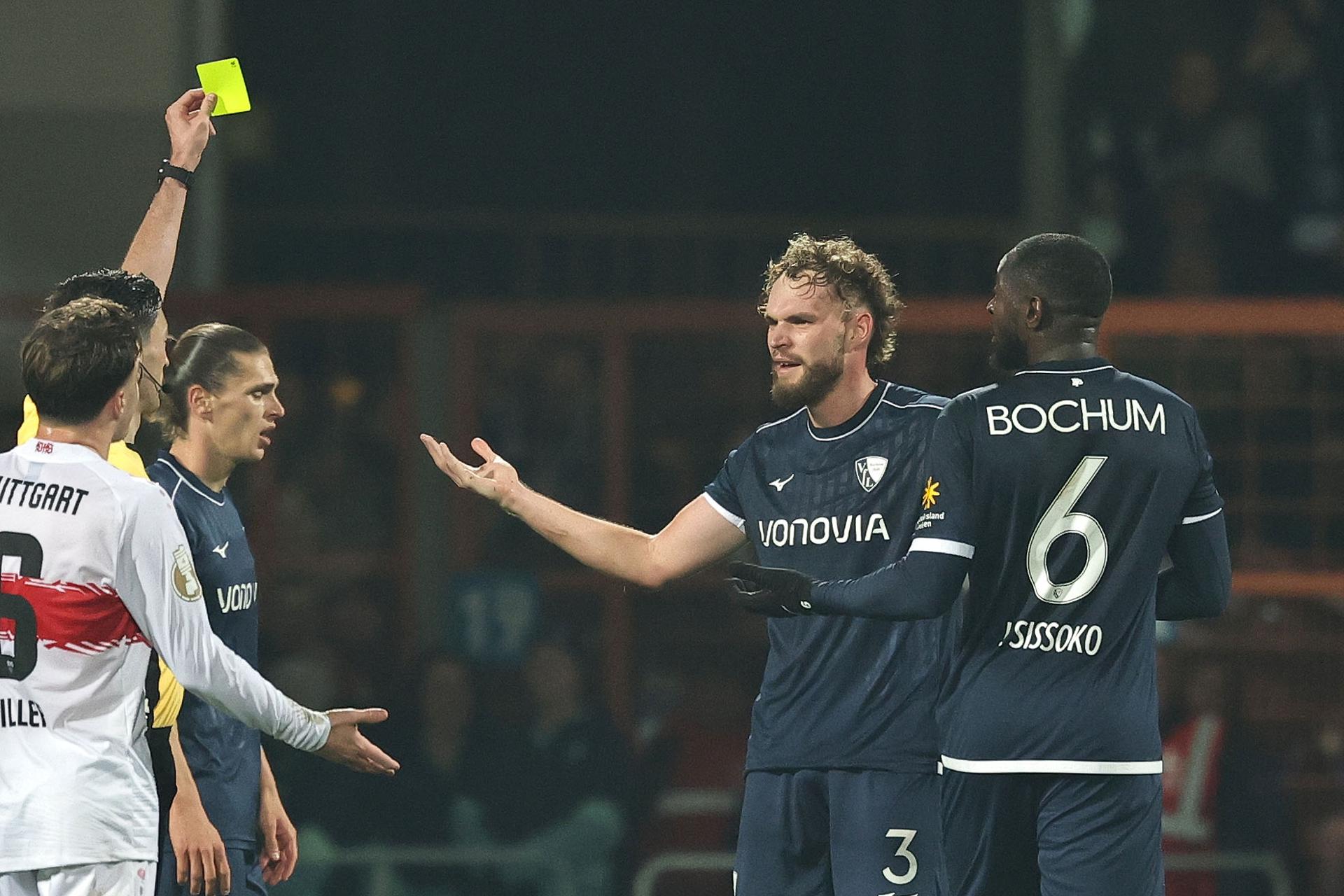 EL jugador del Bochum Philipp Strompf (2-d) ribe una tarjeta amarilla del árbitro Florian Badstueber durante el partido de la DFB Cup que hanjugado VfL Bochum y VfB Stuttgart, en Bochum, Alemania. EFE/EPA/Friedemann Vogel