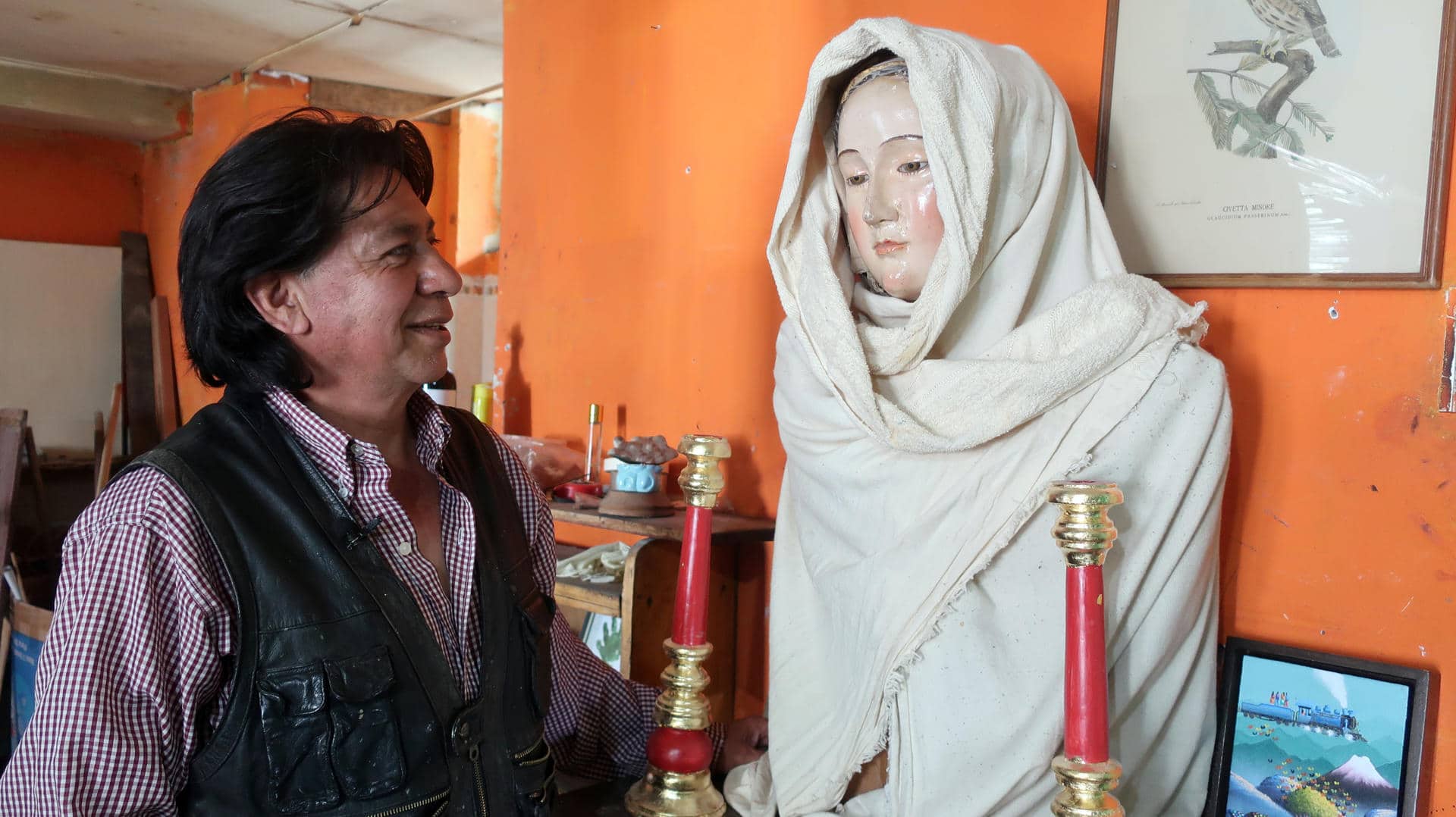 El restaurador de imágenes coloniales Antonio Cuesta observa una pieza antigua en su taller este martes, en Quito (Ecuador). EFE/ Juan Francisco Chávez