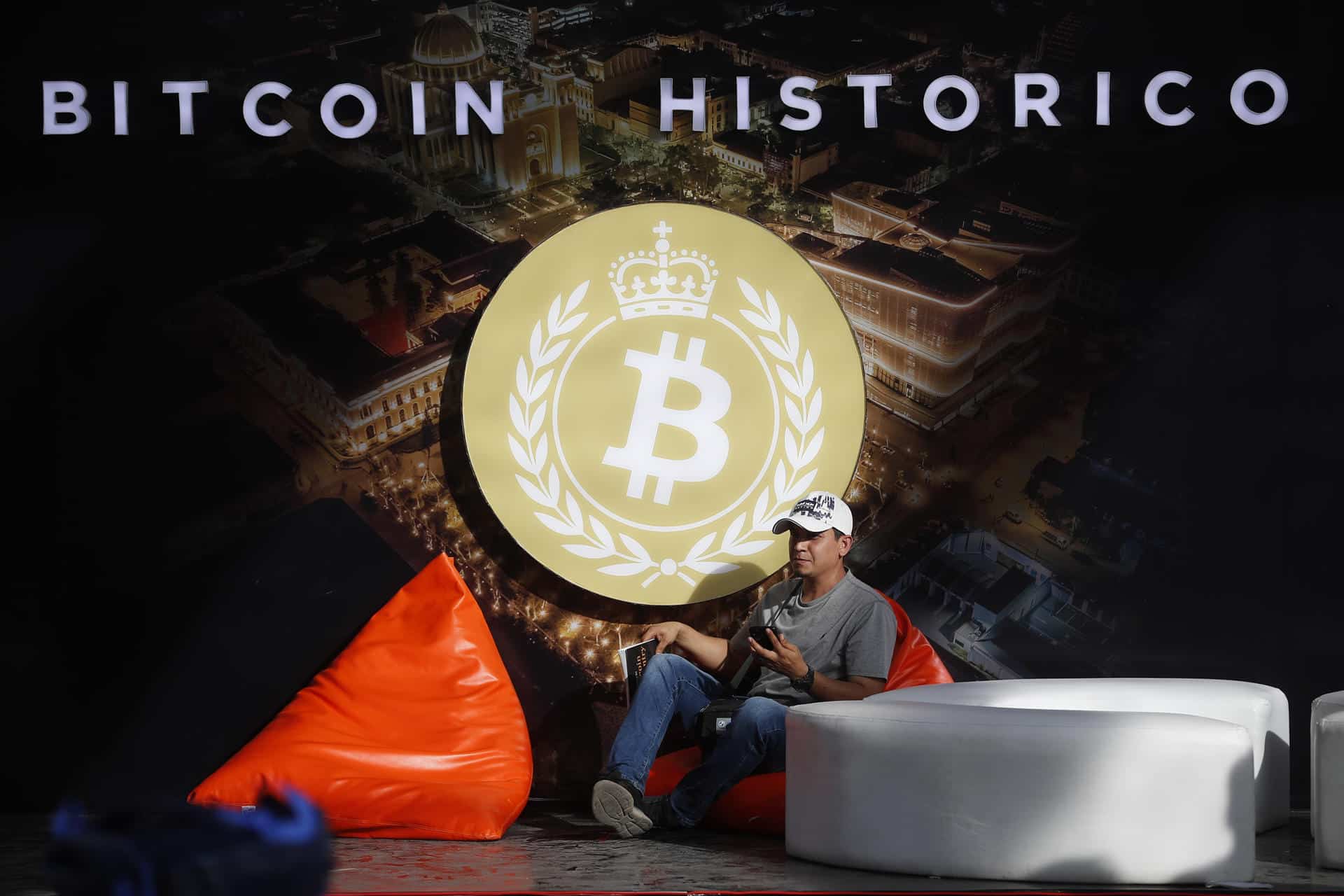 Imagen de archivo de un hombre posando junto al logo de bitcóin en la plaza Gerardo Barrios, en San Salvador (El Salvador). EFE/Rodrigo Sura