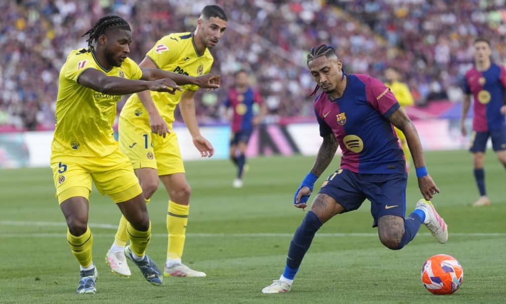 El delantero brasileño del Barcelona Raphinha (d) controla el balón ante dos jugaedores del Villarreal. EFE/ Enric Fontcuberta
