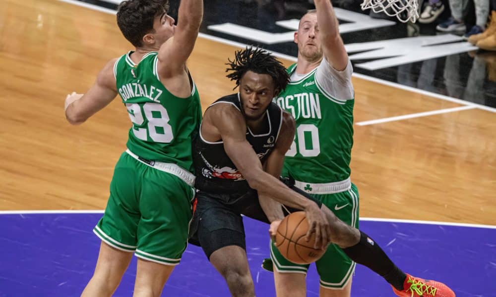 Immanuel Quickley (c), de Toronto Raptors, disputa el balón con Hugo González (i) de Boston Celtics este domingo durante un partido jugado en el Scotiabank Arena en Toronto. EFE/ Julio César Rivas