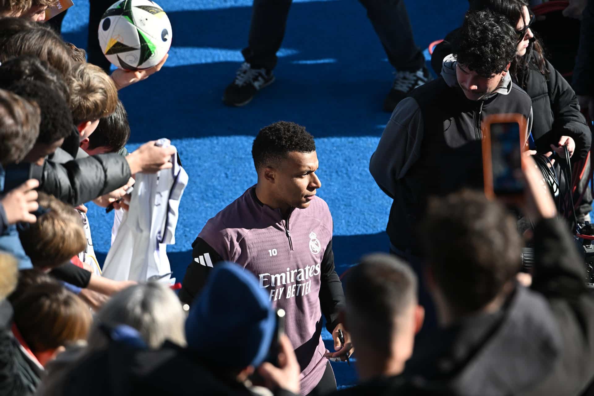 El delantero del Real Madrid Kylian Mbappe firma autógrafos durante el entrenamiento del equipo de este martes celebrado en el estadio Alfredo Di Stéfano, en Valdebebas, que ha sido abierto al público y a los medios de comunicación. El equipo blanco disputa un encuentro de LaLiga el próximo domingo, 4 de enero, frente al Betis. EFE/ Fernando Villar