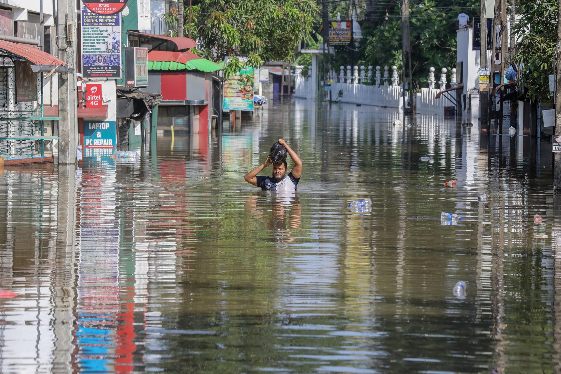 COLOMBO (Sri Lanka), 30/11/2025.- A person wades through a flooded road after heavy rainfall in a suburb of Colombo, Sri Lanka, 30 November 2025. Many parts of the island have been inundated due to heavy rains. According to the Sri Lanka Disaster Management Center, more than 160 people have been killed and about 200 are missing around the country. EFE/EPA/CHAMILA KARUNARATHNE
