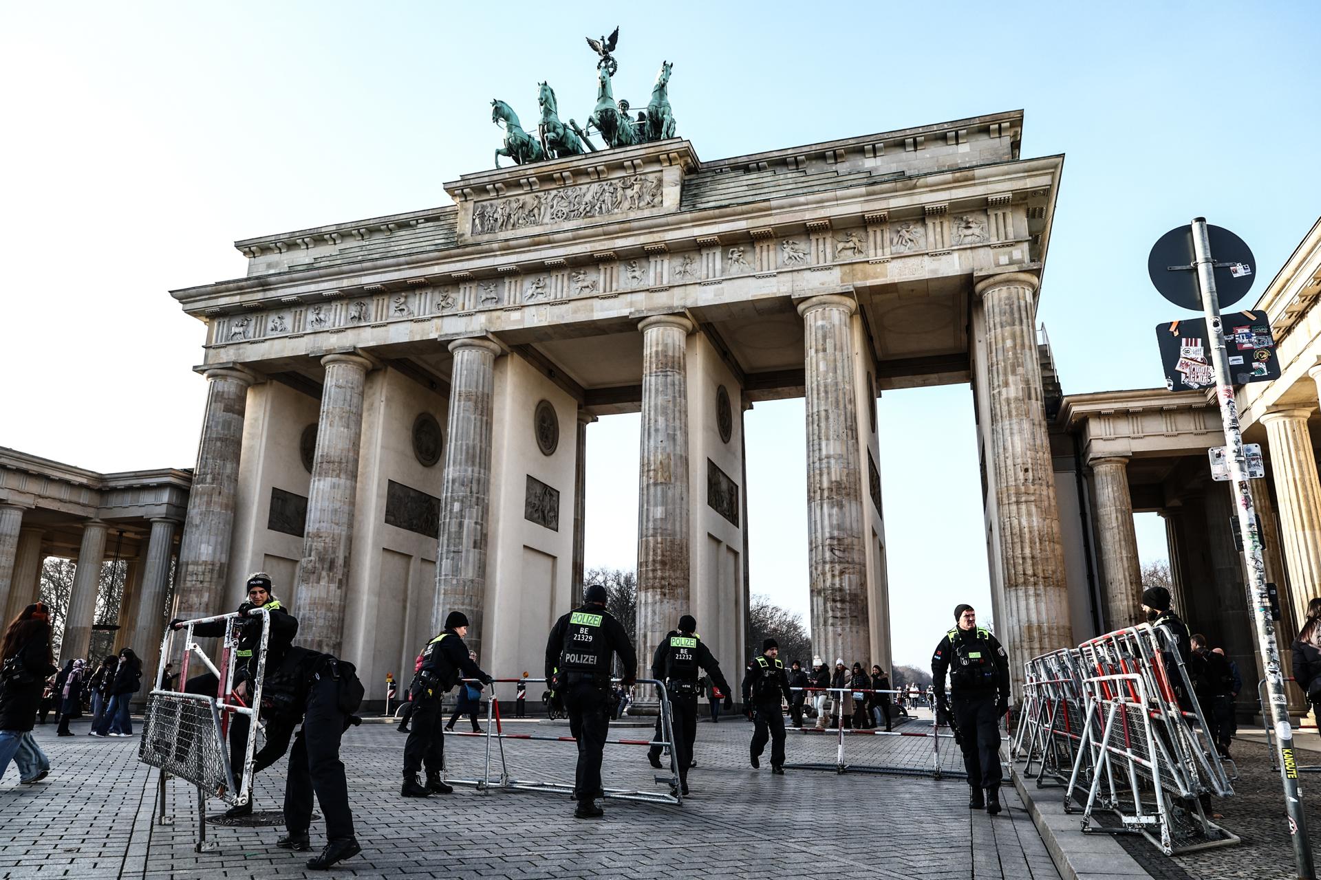 Agentes de policía instalan barreras frente a la Puerta de Brandeburgo como parte del cierre del centro de la ciudad en Berlín, Alemania, 14 de diciembre de 2025. Berlín albergará a las delegaciones de EE.UU. y Ucrania durante el fin de semana para conversaciones sobre un plan de paz propuesto, que incluye un posible alto al fuego en Ucrania. Las discusiones serán seguidas por una cumbre en Berlín con líderes europeos y el presidente Volodymyr Zelensky. (Alemania, Ucrania) EFE/EPA/FILIP SINGER