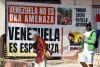 Personas caminan frente a un cartel alusivo a Venezuela durante una manifestación en apoyo al presidente Nicolás Maduro este sábado, en La Habana (Cuba). EFE/ Ernesto Mastrascusa