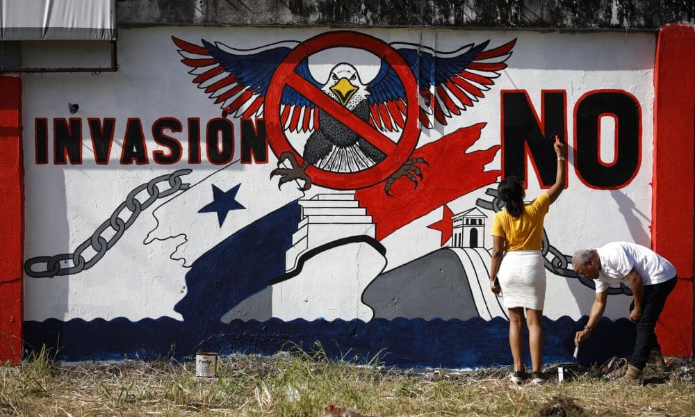 Fotografía de archivo donde se observa a una pareja pintando un mural en la provincia de Colón (Panamá) relacionado con la invasión por parte de Estados Unidos. EFE/ Bienvenido Velasco