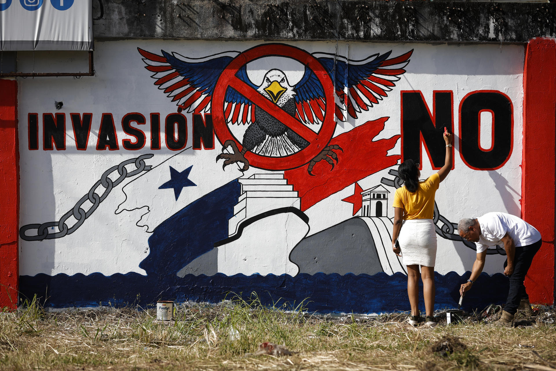 Fotografía de archivo donde se observa a una pareja pintando un mural en la provincia de Colón (Panamá) relacionado con la invasión por parte de Estados Unidos. EFE/ Bienvenido Velasco