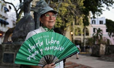 ACOMPAÑA CRÓNICA: PUERTO RICO ABORTO USA7381. SAN JUAN (PUERTO RICO), 27/12/2025.- Una mujer sostiene un abanico con un mensaje alusivo al aborto durante una manifestación realizada el 22 de diciembre de 2025 en la plaza La Rogativa ubicada frente a la sede del Gobierno en San Juan (Puerto Rico). Una ola de activistas feministas encara la amenaza que pone en jaque el aborto libre en Puerto Rico, tras la reciente decisión de la gobernadora, Jenniffer González, de convertir en ley una medida que reconoce al no nacido como persona natural. EFE/Thais Llorca