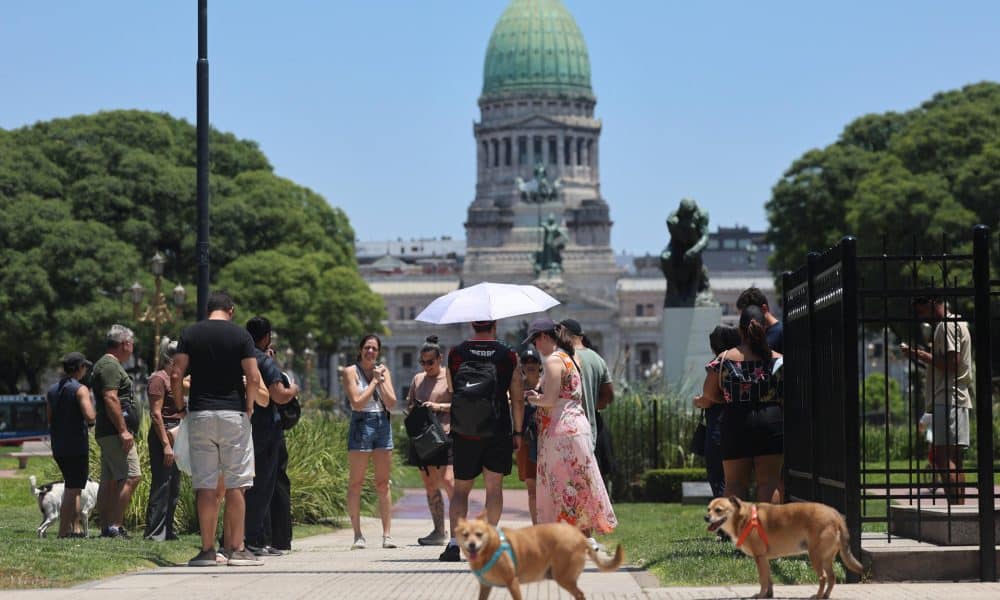 Personas caminan y se protegen del sol este martes, frente al Congreso en Buenos Aires (Argentina). EFE/ Juan Ignacio Roncoroni