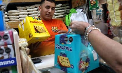 Personas sostienen cajas con panetones en una tienda este martes, en Lima (Perú). EFE/ Paolo Aguilar