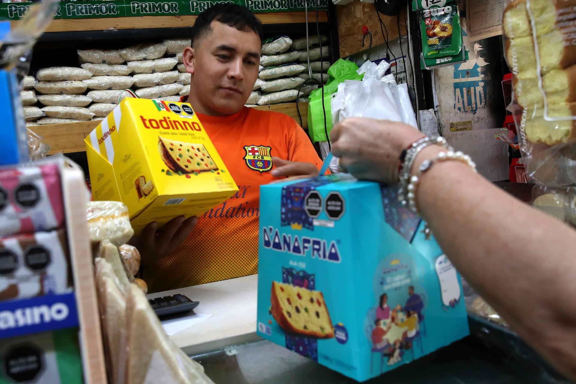 Personas sostienen cajas con panetones en una tienda este martes, en Lima (Perú). EFE/ Paolo Aguilar