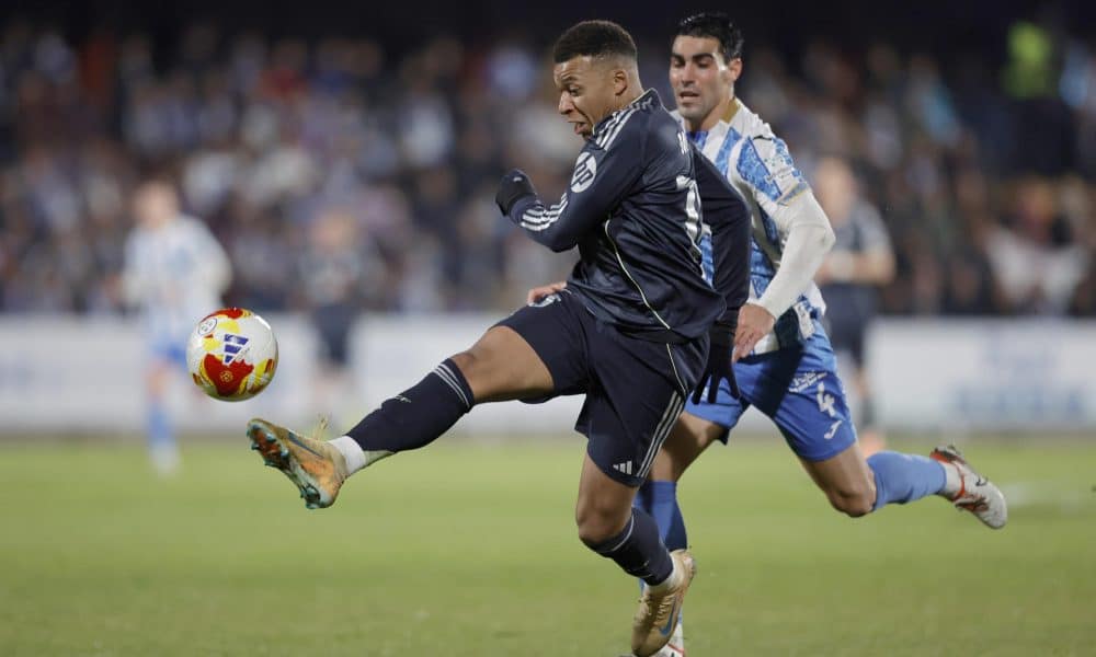 El delantero francés del Real Madrid, Kylian Mbappé, golpea el balón ante el jugador del Talavera, Álvaro López, durante el partido de dieciseisavos de final de la Copa del Rey que Talavera CF y Real Madrid disputaron en el estadio de El Prado. EFE/Manu Reino