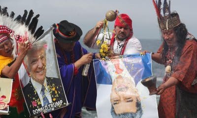 Un grupo de chamanes y curanderos sostienen carteles con las imágenes de los presidentes de Estados Unidos, Donald Trump, y de Venezuela, Nicolás Maduro, durante un ritual de fin de año frente al océano Pacífico este lunes, en Lima (Perú). EFE/ Paolo Aguilar