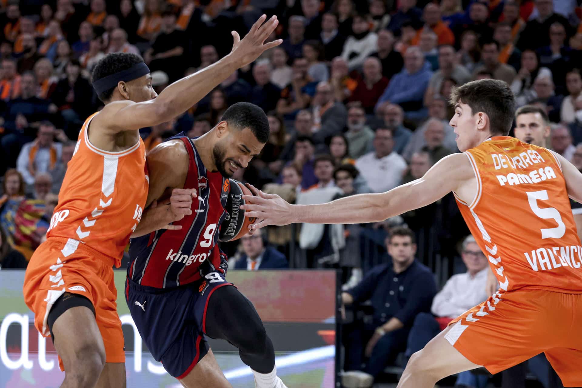 El jugador del Baskonia Timothe Luwawu-Cabarrot (c) juega un balón ante Kameron Taylor (i), del Valencia Basket, durante el partido de baloncesto correspondiente a la jornada 18 de la Euroliga entre el Baskonia y el Valencia Basket en el Roig Arena de Valencia. EFE/ Miguel Ángel Polo