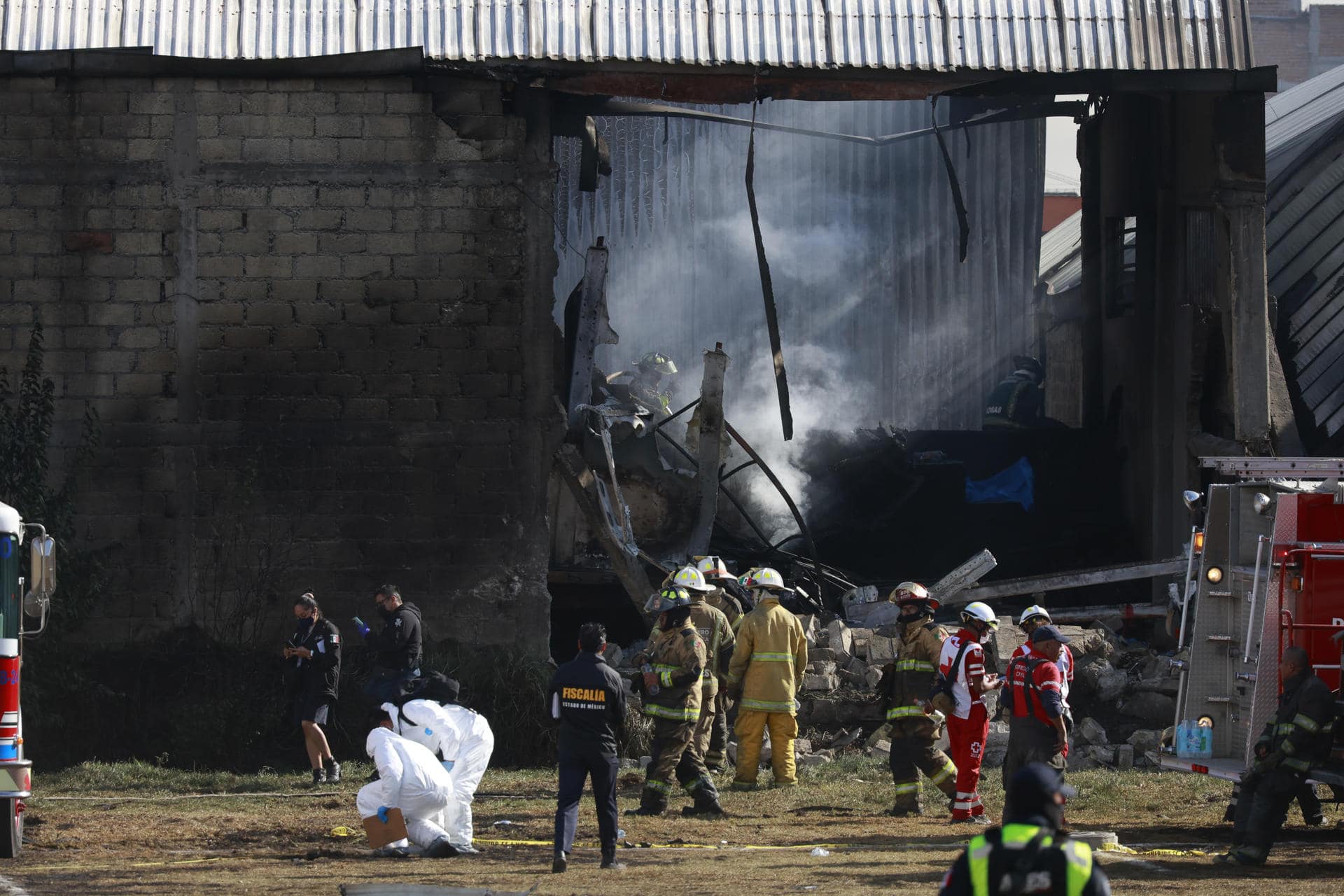 Integrantes de Protección Civil, bomberos y peritos forenses trabajan en la bodega industrial donde cayó una avioneta Cessna Citation 650 este lunes, en el municipio de San Mateo Atenco, en el estado de México (México). EFE/ Felipe Gutiérrez