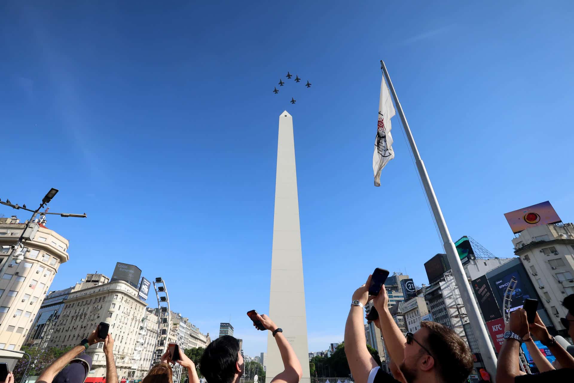 Personas observan aviones F16 de la Fuerza Aérea Argentina sobre el Obelisco este sábado, en Buenos Aires (Argentina). EFE/ Juan Ignacio Roncoroni