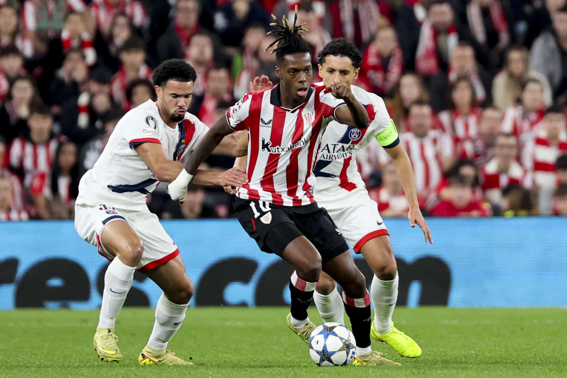 El delantero del Athletic Club, Nico Williams (c), intenta llevarse el balón ante los jugadores del PSG durante el encuentro correspondiente a la fase regular de la Liga de Campeones que disputan Athletic Club y PSG en el estadio de San Mamés, en Bilbao. EFE/Luis Tejido.