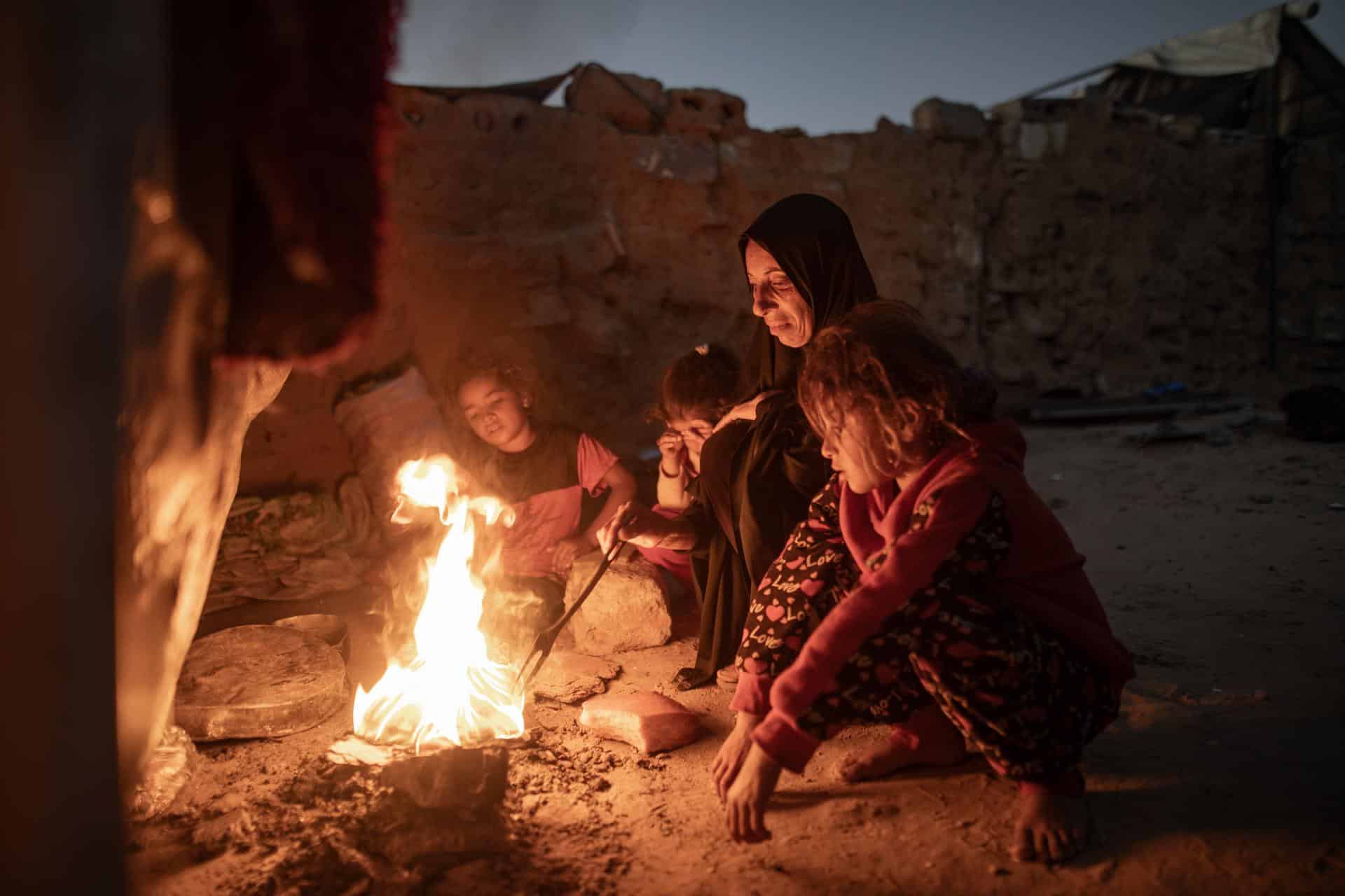 Una mujer palestina desplazada internamente Sabrin cocina sobre una fogata en un campamento informal en Khan Younis, en la franja de Gaza sur, el 30 de noviembre de 2025. 
EFE/EPA/HAITHAM IMAD
