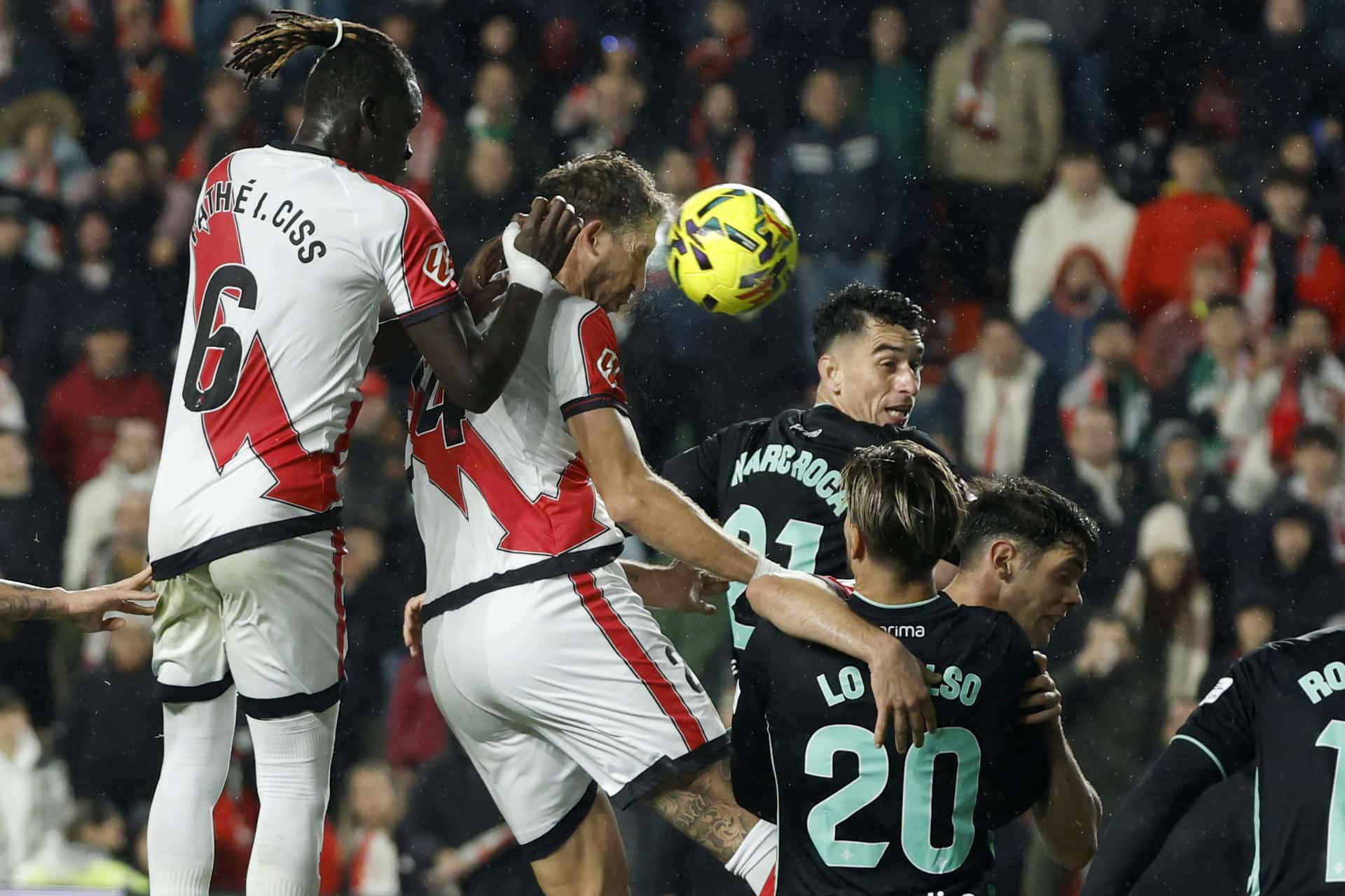 El defensa francés del Rayo Florian Lejeune (2i) remata de cabeza durante el partido de la jornada 16 de LaLiga de fútbol que Rayo Vallecano y Real Betis disputan este lunes en el estadio de Vallecas, en Madrid. EFE/Juanjo Martín