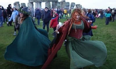 Dos mujeres bailan este domingo ante el monumento megalítico de Stonehenge, cerca de Amesbury (Reino Unido), para celebrar el solsticio de invierno, el día más corto del año en el hemisferio norte. EFE/EPA/NEIL HALL