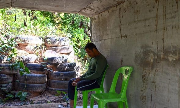 Dong Rak (Thailand), 08/12/2025.- A Thai villager monitors the situation via a mobile phone as he takes shelter under a concrete bunker following clashes between Thai and Cambodian troops in Phanom Dong Rak district, Surin province, Thailand, 08 December 2025.The Royal Thai Army has reported a Thai soldier was killed and other eight wounded in the multiple border area clashes between Thai and Cambodian troops after Cambodian troops attacked in the Phu Pha Lek hill of Phlan Hin Paet Kon area in Kantharalak district, Si Sa Ket province that prompted the evacuation of residents in four northeastern provinces bordering Cambodia, according to Thai Army spokesman Major General Winthai Suvaree. (Camboya, Tailandia) EFE/EPA/KAIKUNGWON DUANJUMROON