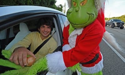 Fotografía cedida por la Oficina del Sheriff del Condado de Monroe que muestra al coronel retirado Lou Caputo disfrazado del Grinch (d), ofreciendo una cebolla a una persona que conducía con un ligero exceso de velocidad este viernes, en la zona escolar de Cayo Largo, Florida, (EE.UU.). EFE/ Andy Newman/ Oficina Sheriff Del Condado Monroe /SOLO USO EDITORIAL/ NO VENTAS/ SOLO DISPONIBLE PARA ILUSTRAR LA NOTICIA QUE ACOMPAÑA (CRÉDITO OBLIGATORIO)