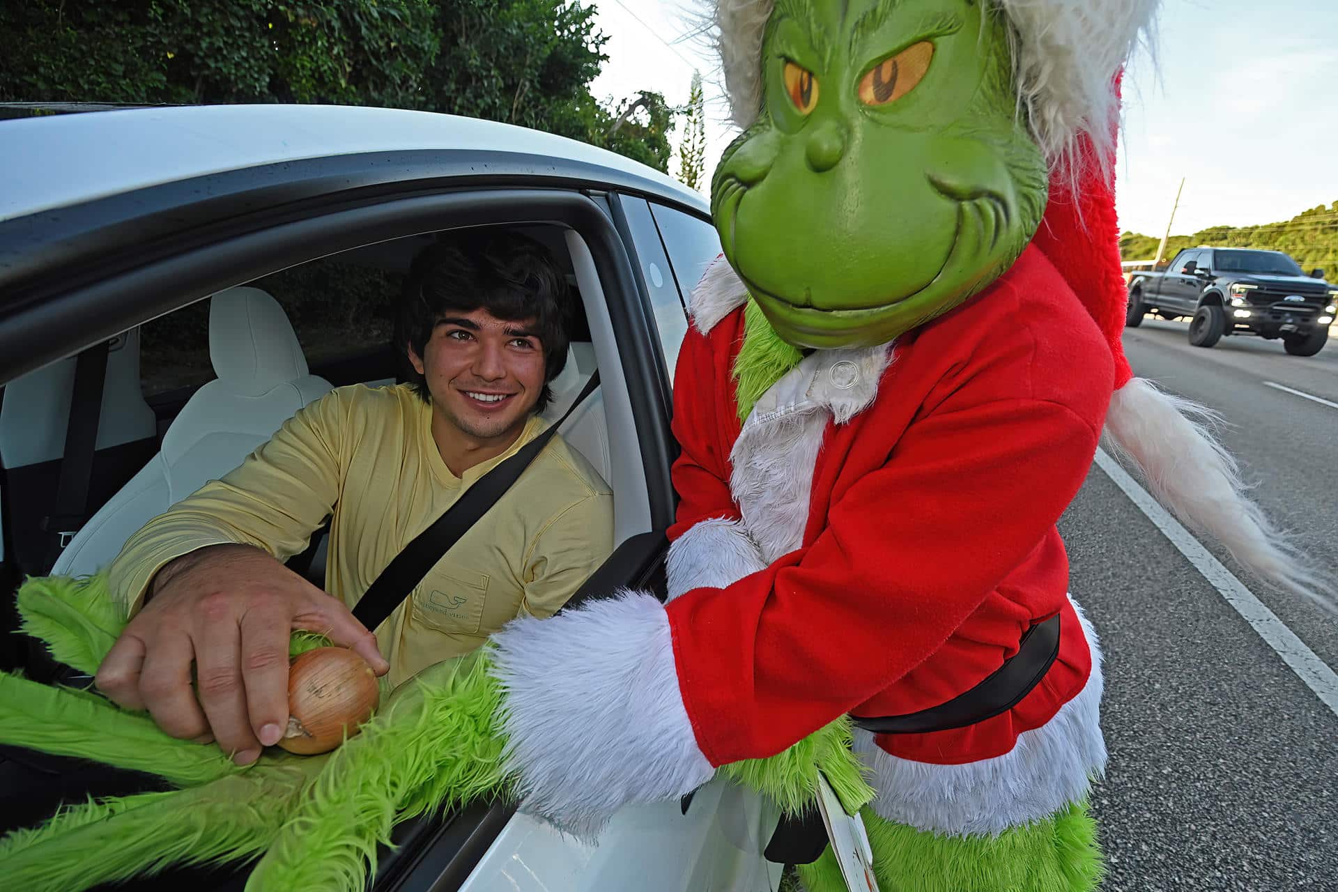 Fotografía cedida por la Oficina del Sheriff del Condado de Monroe que muestra al coronel retirado Lou Caputo disfrazado del Grinch (d), ofreciendo una cebolla a una persona que conducía con un ligero exceso de velocidad este viernes, en la zona escolar de Cayo Largo, Florida, (EE.UU.). EFE/ Andy Newman/ Oficina Sheriff Del Condado Monroe /SOLO USO EDITORIAL/ NO VENTAS/ SOLO DISPONIBLE PARA ILUSTRAR LA NOTICIA QUE ACOMPAÑA (CRÉDITO OBLIGATORIO)
