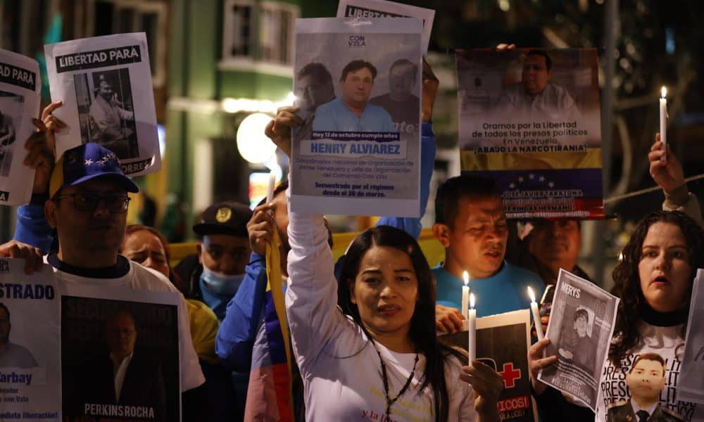 Personas sostienen carteles y velas durante la manifestación 'Marcha por la Paz y la Libertad' que exige la liberación de presos políticos en Venezuela este miércoles, en Bogotá (Colombia). EFE/ Mauricio Dueñas Castañeda