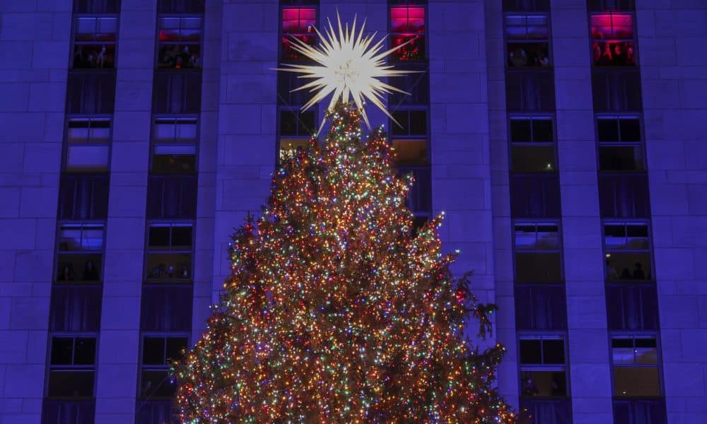 Personas dentro del edificio observan el árbol de Navidad del Rockefeller Center después de encenderse durante la ceremonia de iluminación en Nueva York, EE.UU., el 3 de diciembre de 2025. EFE/EPA/SARAH YENESEL