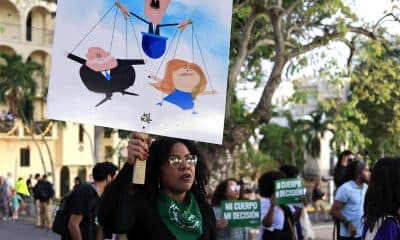 Una mujer sostiene un cartel durante una manifestación este 22 de diciembre de 2025, en San Juan (Puerto Rico). EFE/ Thais Llorca
